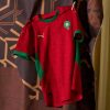 maillot-domicile-equipe-du-maroc-saison-deux-mille-vingt-quatre-deux-mille-vingt-cinq-rouge-et-vert Hemmatröja för Marockos landslag säsongen tvåtusentjugofyra tvåtusentjugofem röd och grön